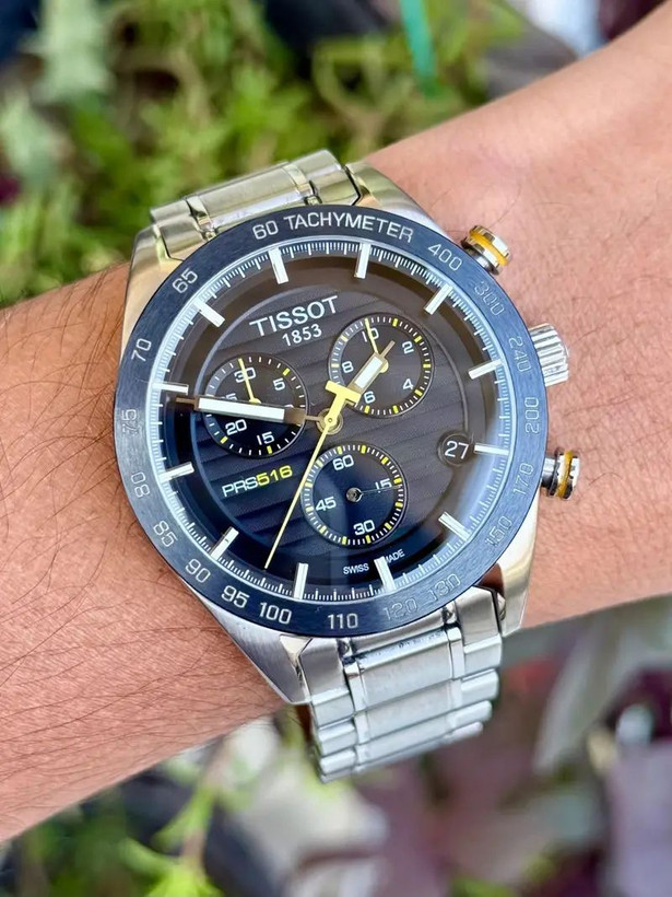 TISSOT prs516 سه موتور کرنوگراف موتور ژاپن دارای روز شمار قفل استیل پروانه ای (مخفی) بند استیل رنگ ثابت موتورکوارتز کرنو ضدآب قاب طلایی کرنوگراف
